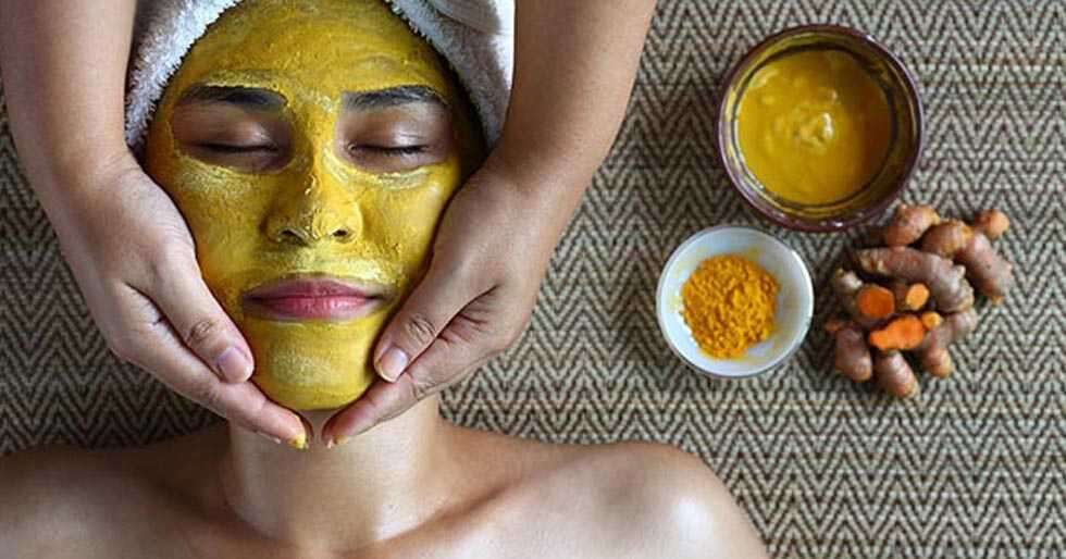 Ayurvedic face pack of chandan,Haldi, and gulab jal or gulab ka pani, with  raw turmeric, sandal wood powder and rose petals on wooden surface for good  and natural bright, white skin. Stock