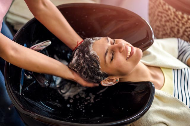 woman washin hair with a sulphate-free, paraben-free shampoo