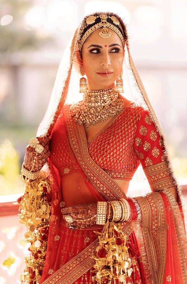 Photo of A beautiful bride in a stunning dark red lehenga and subtle makeup.