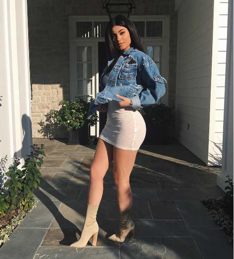 KYLIE JENNER The youngest of the Kardashian-Jenner clan wears her denim cover-up as a layer over a body-hugging little dress complete with ankle-high boots.