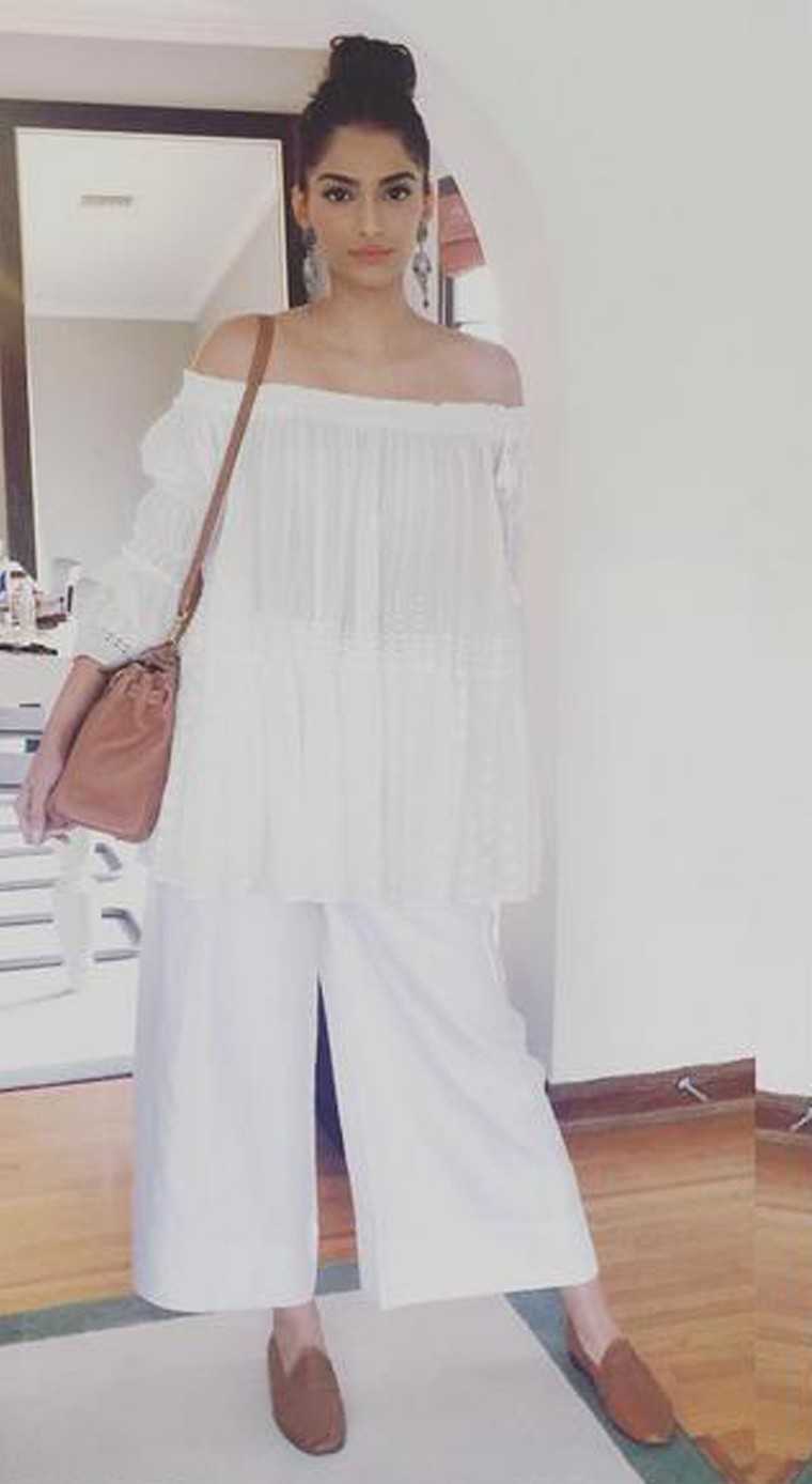 Sonam Kapoor goes all-white in her oversized Chloé peasant blouse and culottes.  She adds tan accessories and silver earrings to the mix.